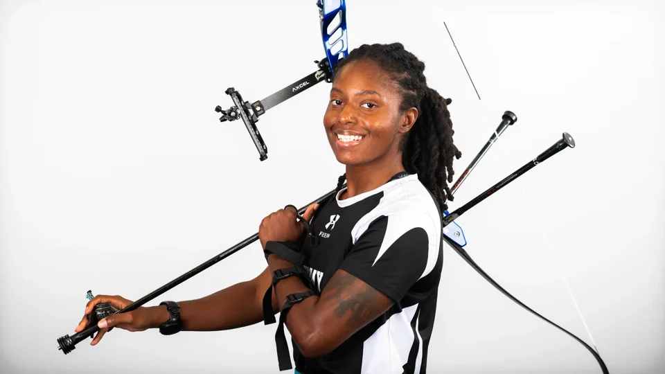 Jani Merritt smiling with her archery bow